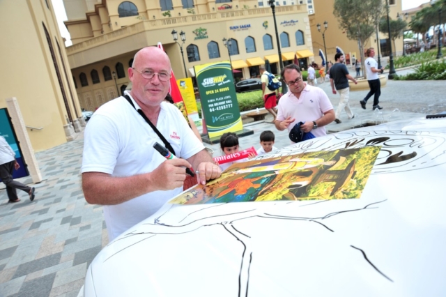 DAVE SIGNING ONE OF THOUSANDS OF DARUMA POSTERS HANDED OUT ALL OVER THE UAE